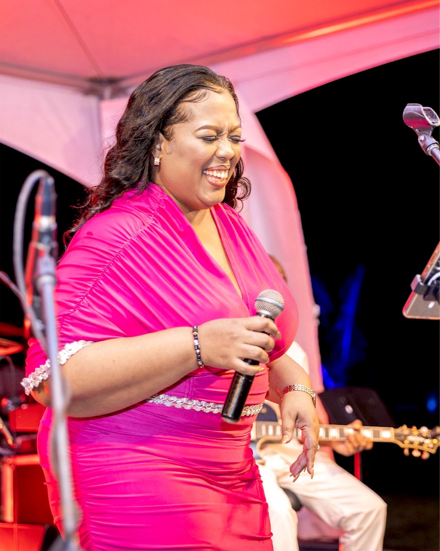 Queen B laughing on stage in pink