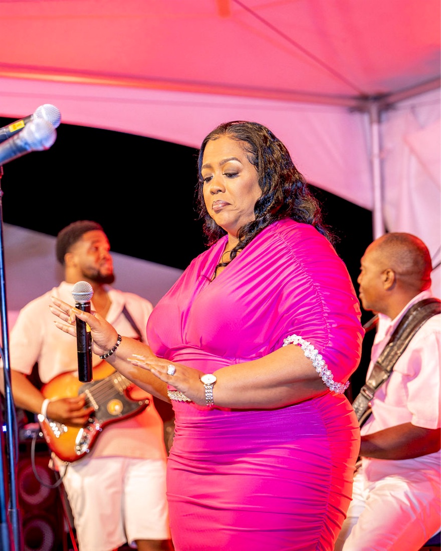 Queen B in pink with guitar and band