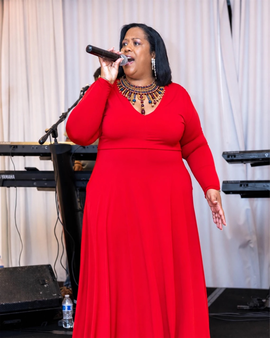Queen B singing in a red gown