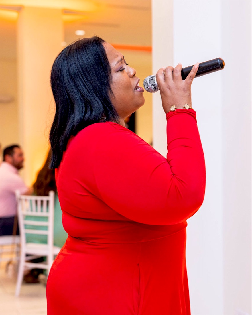 Queen B singing in red in profile