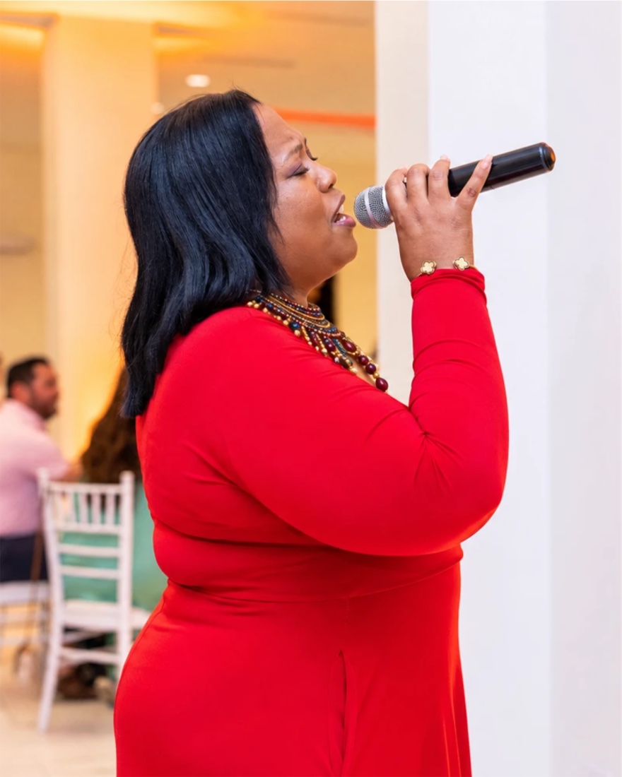 Queen B singing in red in profile