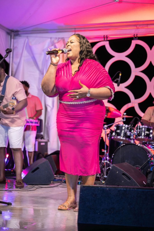 Queen B in pink performing on a night stage