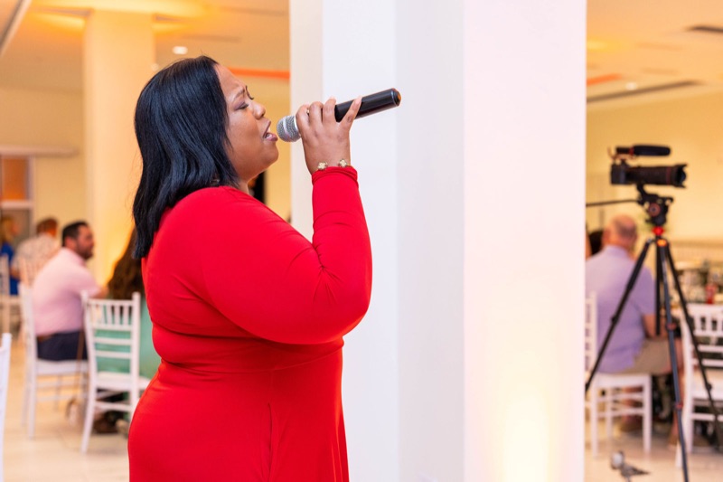 Queen B in red singing in profile