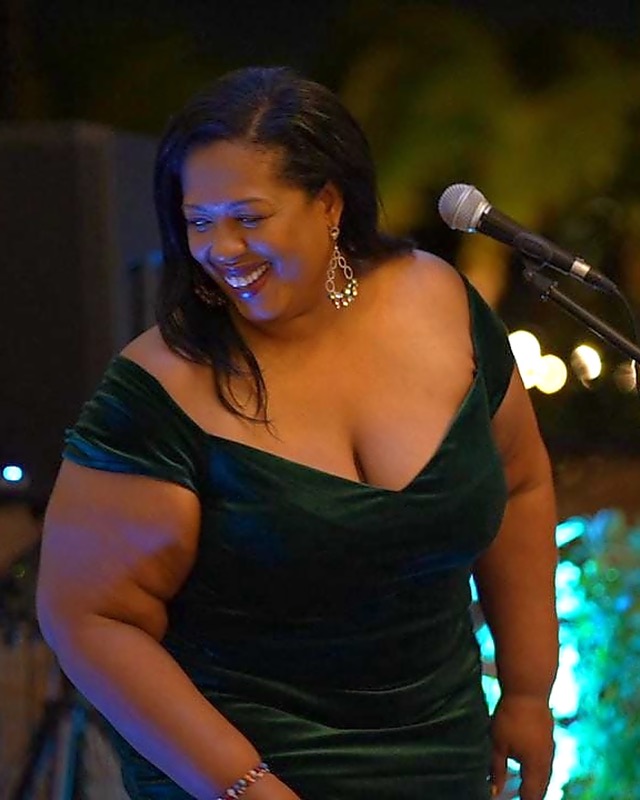 Queen B smiling on stage in green velvet